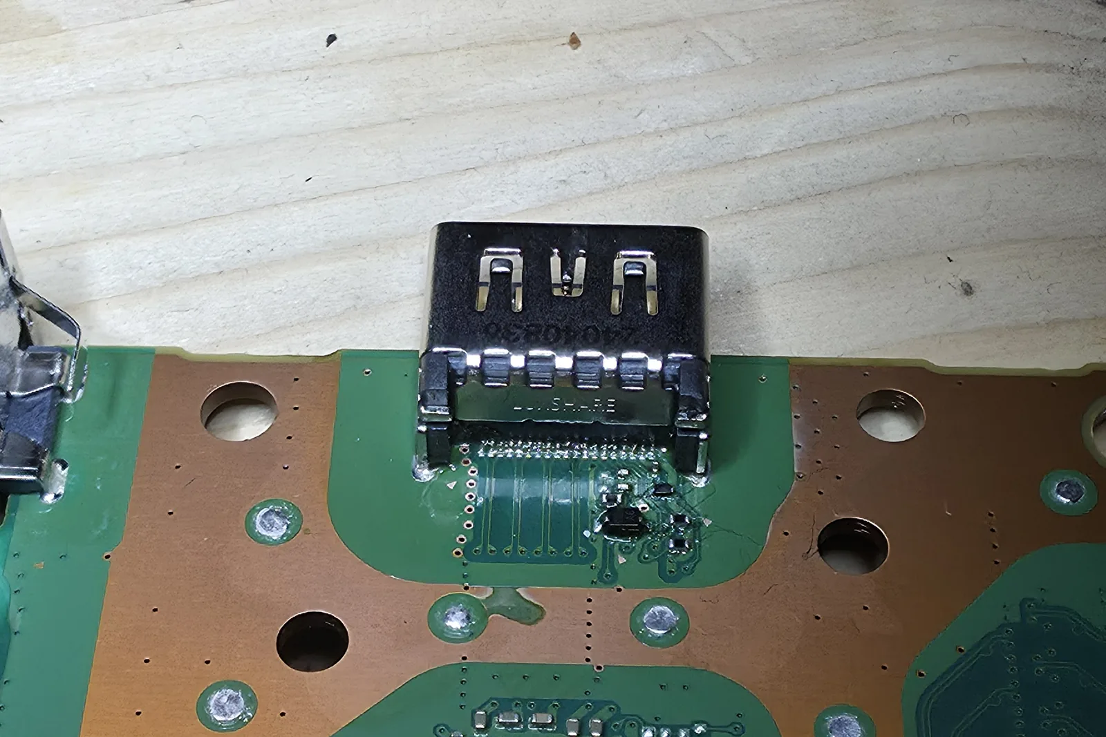 The same PS5 board after repair: a new HDMI port fitted, pins cleanly soldered.