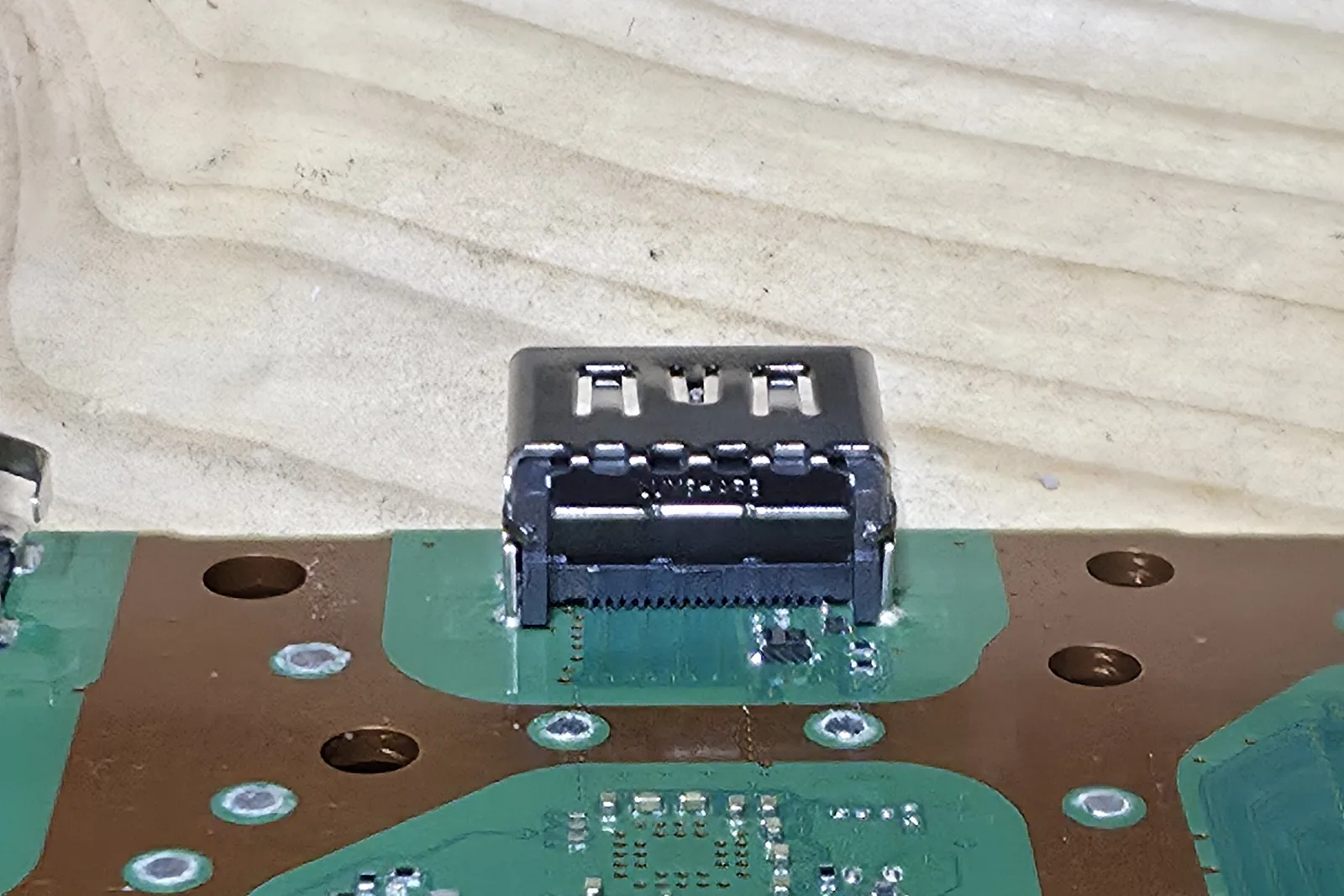 A PS5 board with a burnt HDMI port, the casing scorched and the pins damaged.